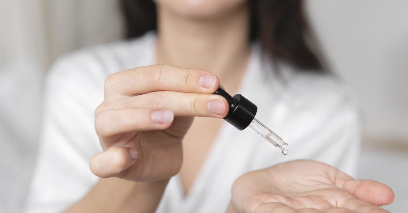 woman drops exosome serum into her hands