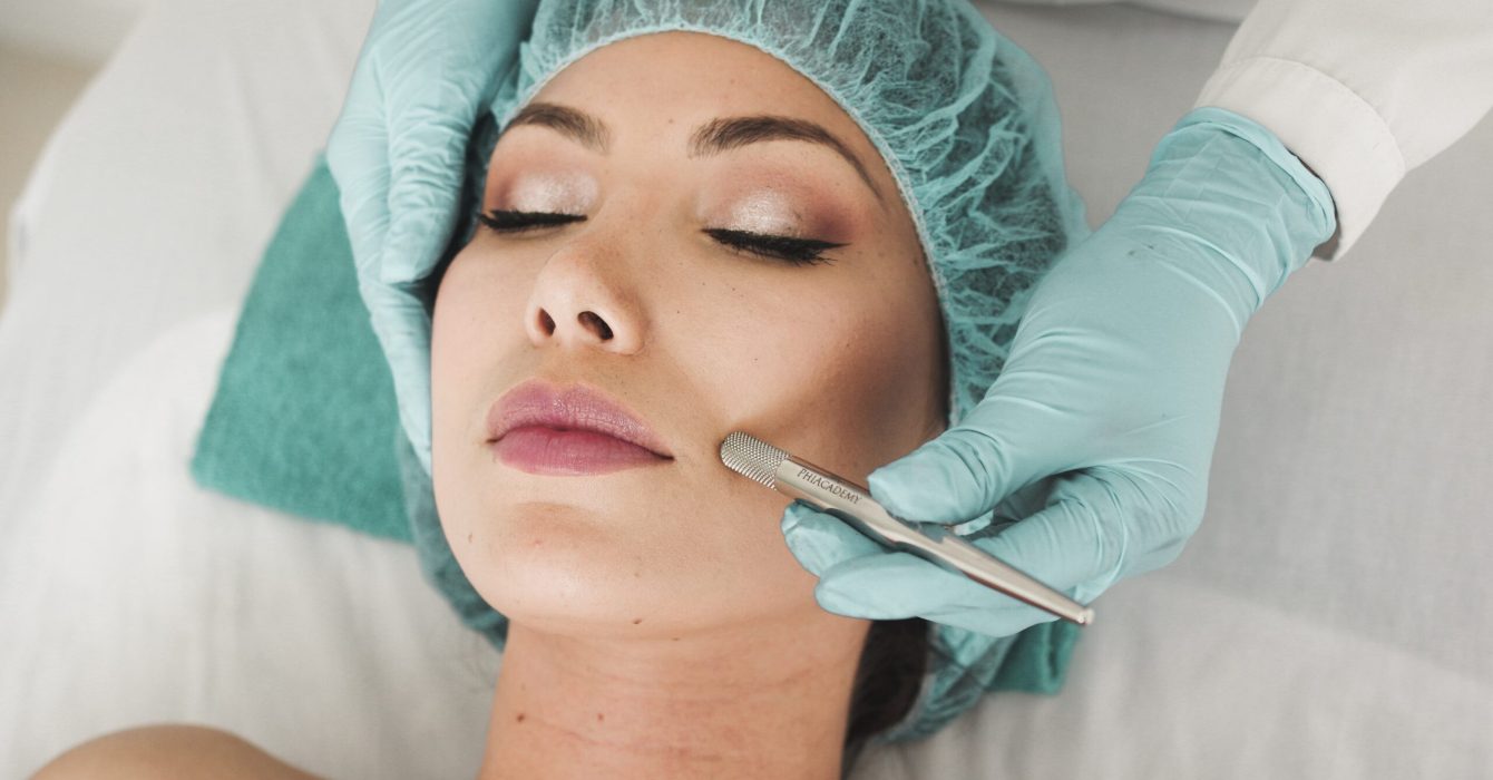 Woman wearing surgical cap undergoing a beauty therapy