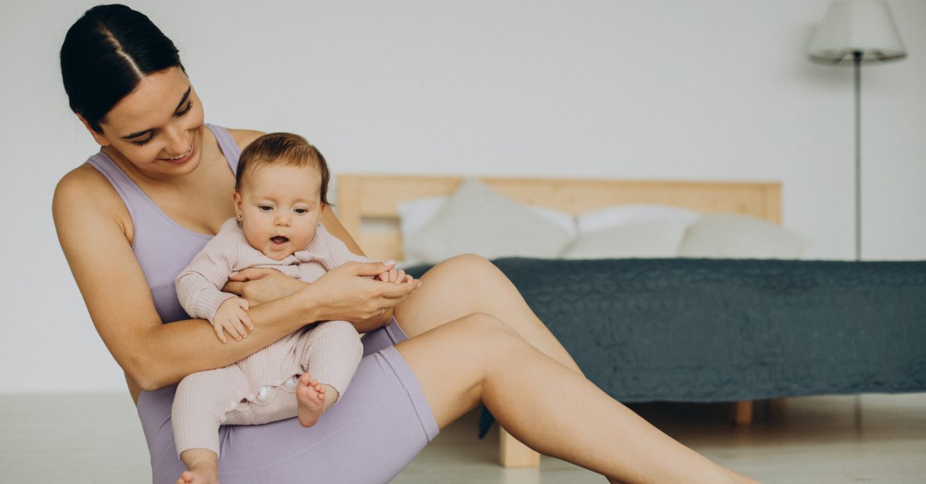 woman sitting on exercise mat to work out with baby