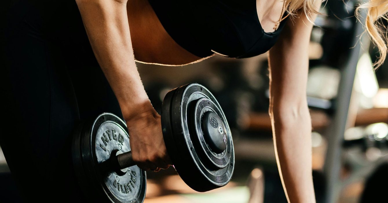 Woman lifts dumbbell in gym