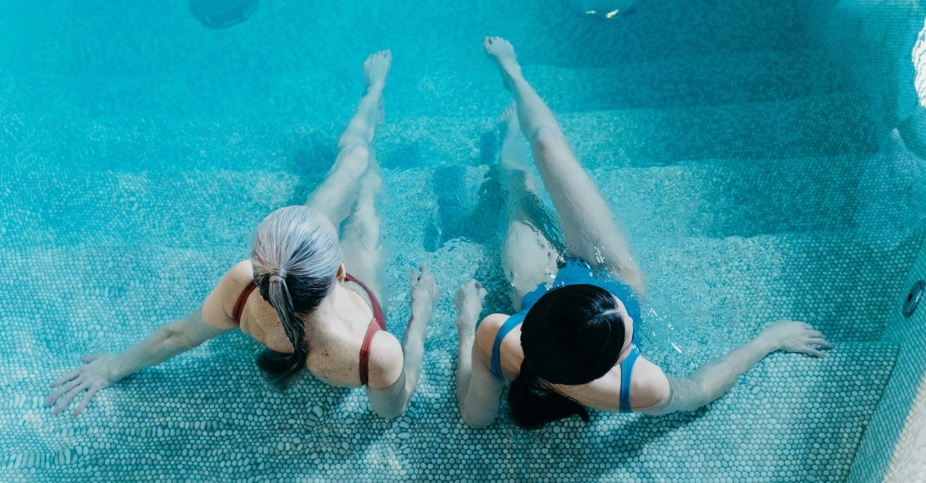 Two women sitting in a pool