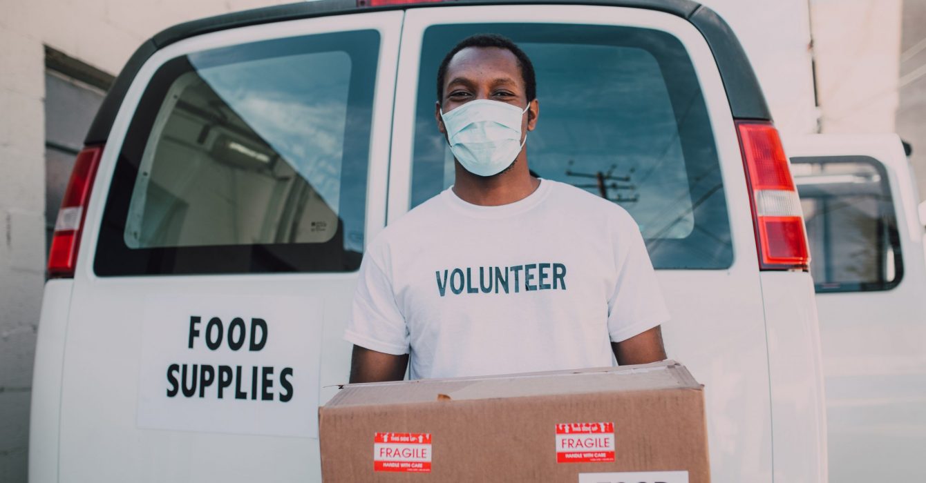 A volunteer for a charity helps with the delivery of food