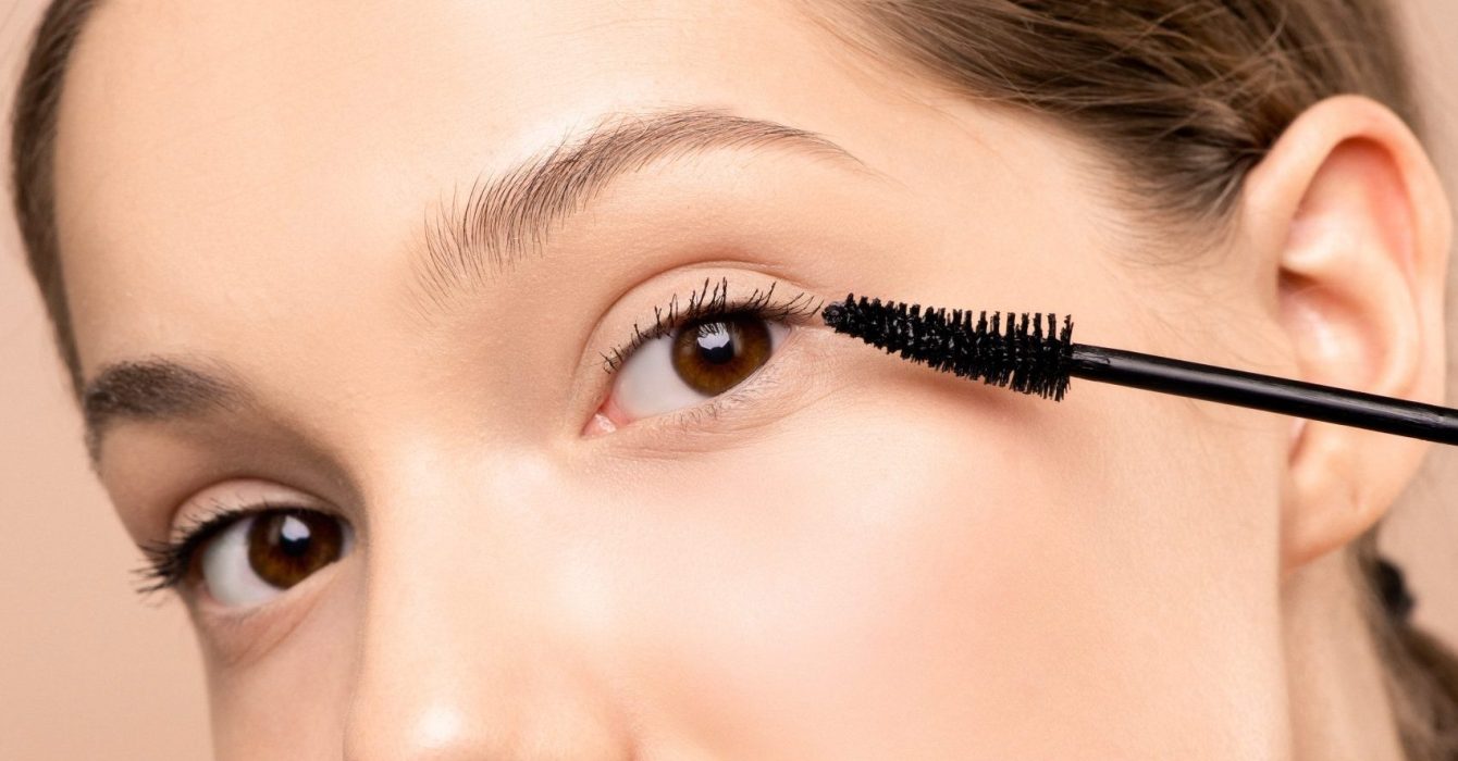 close up of woman applying a waterproof mascara to one eye