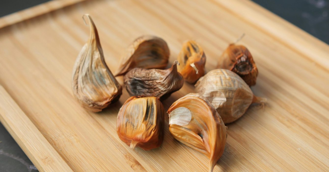 black garlic on a wooden chopping board