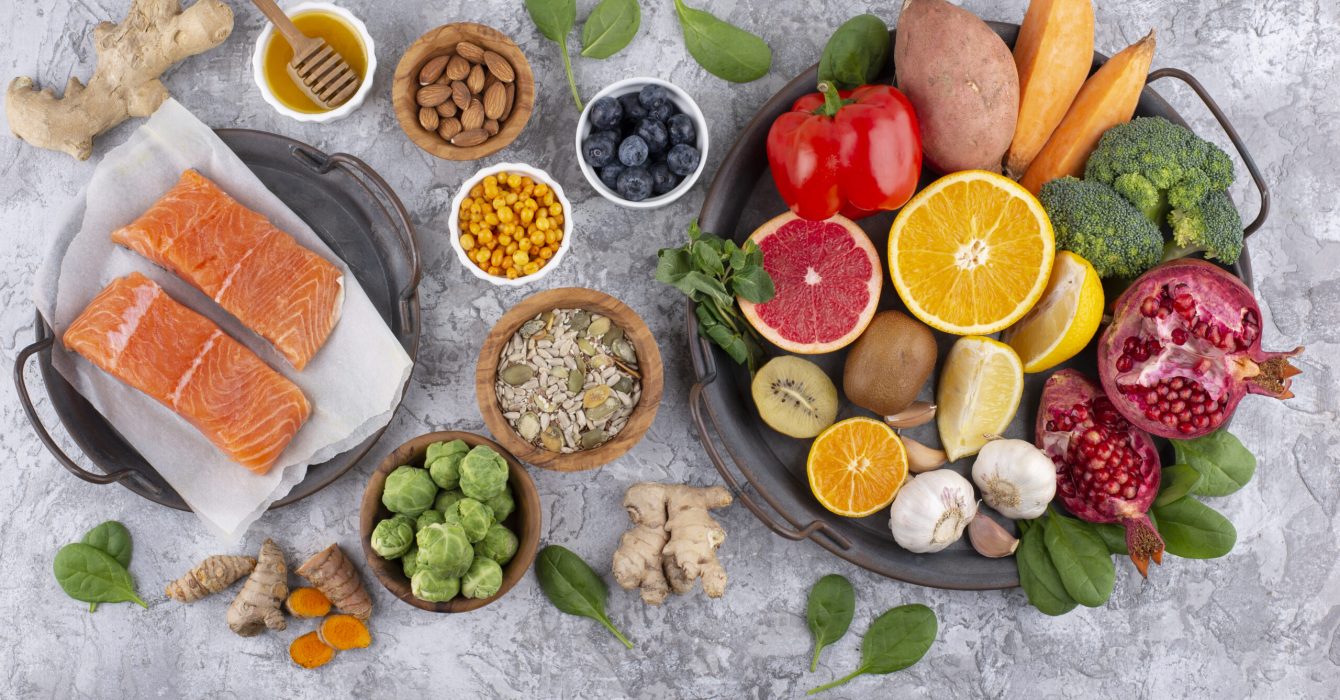 An array of food which support a healthy immune system. It includes salmon, citrus fruit and red peppers.