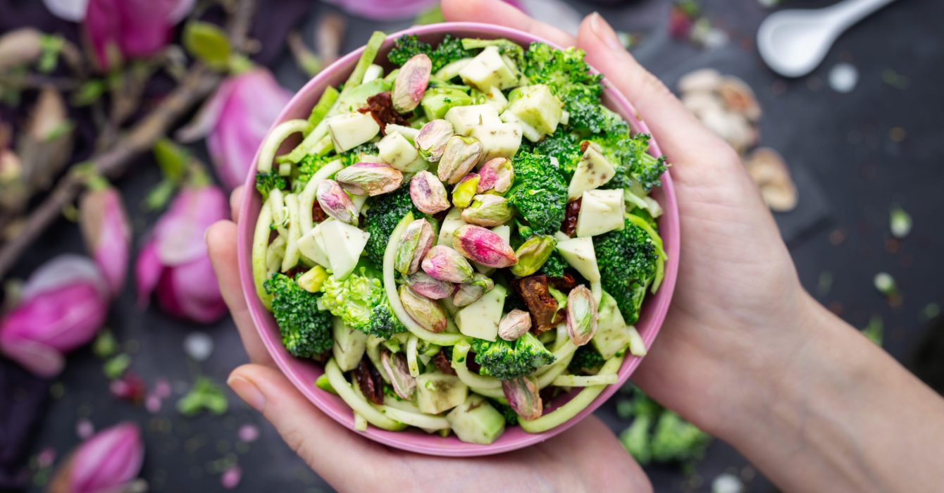 A top view of a person holding a bowl of the delicious vegan salad
