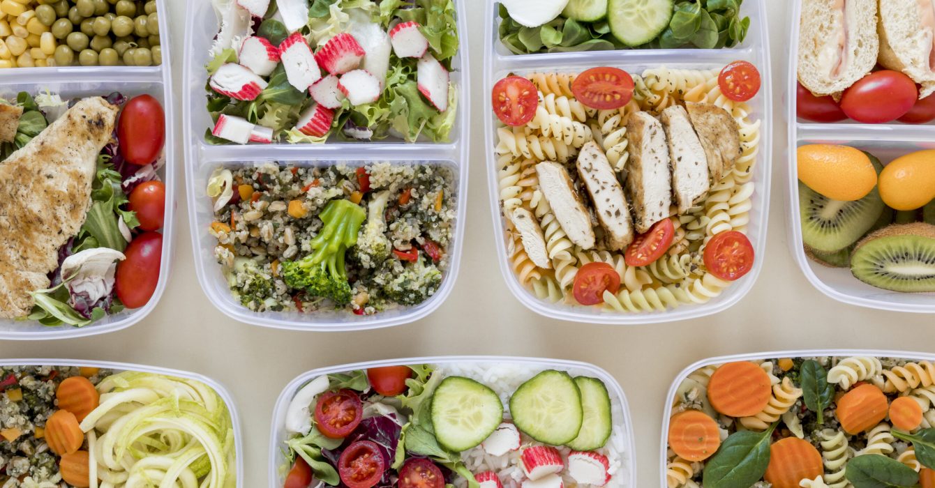 Several food storage containers filled with a variety of meals.