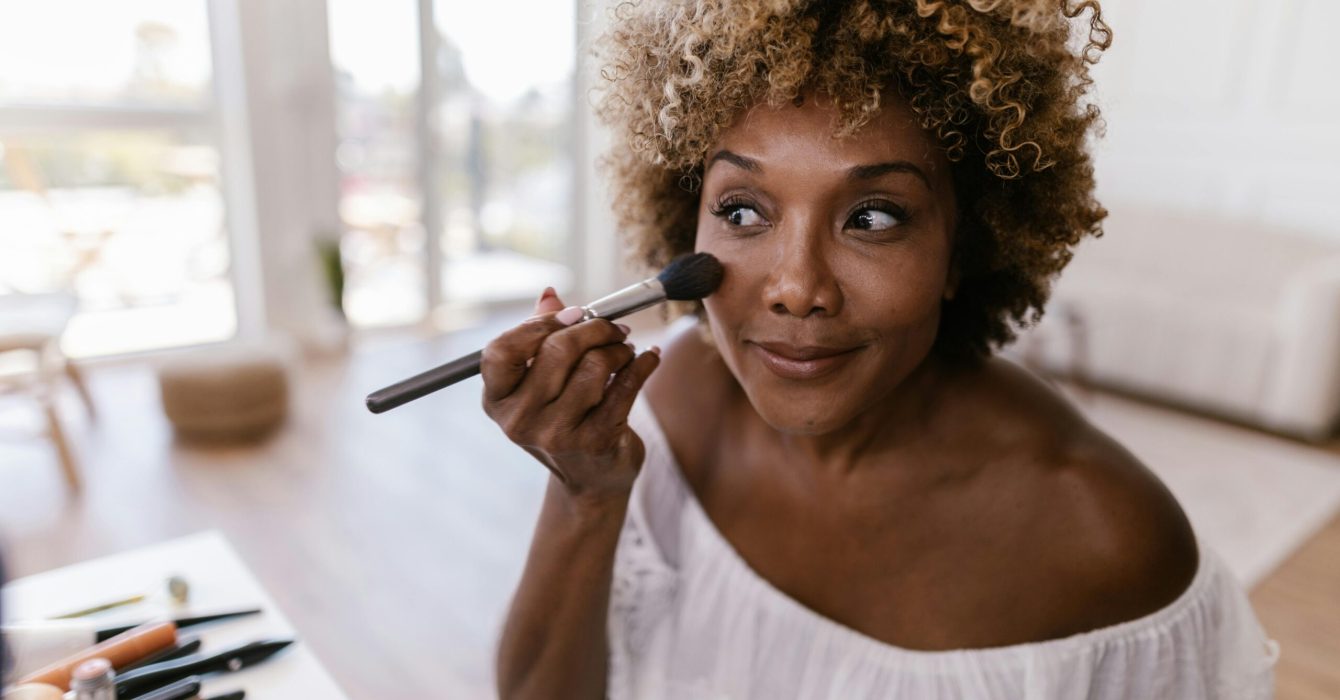 woman applies cream makeup