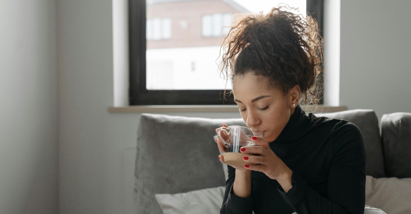 woman in bed sipping a tea with shilajit inside